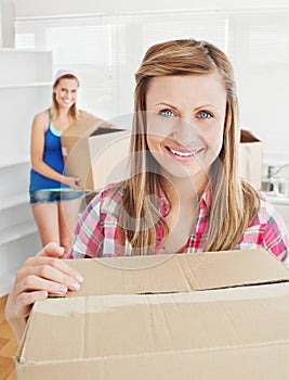 Delighted woman holding boxes after moving