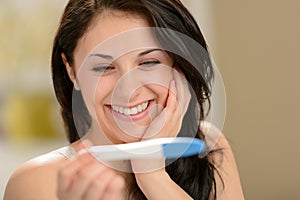 Delighted woman holding pregnancy test