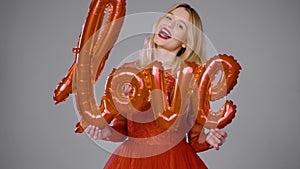 Delighted woman playing with air balloon in studio