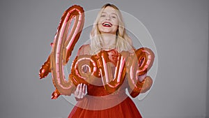 Delighted woman playing with air balloon in studio