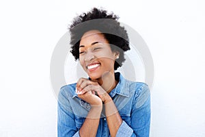 Delighted woman smiling by white wall