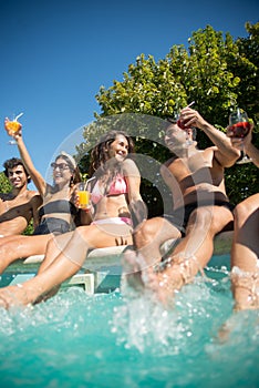 Delighted young friends having fun near swimming pool