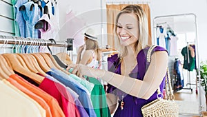 Delighted young woman choosing clothes