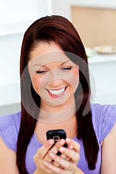Delighted young woman sending a text