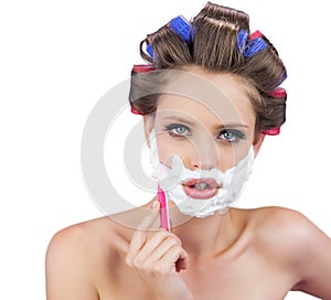 Delightful model in hair curlers posing with razor