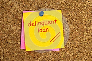 Delinquent loan postit on cork