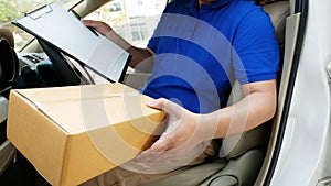 Deliverer sitting in a van holding a box