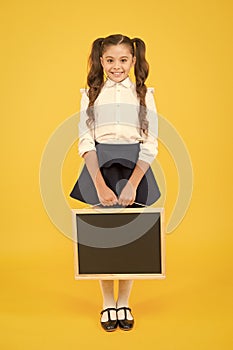 Delivering fresh information. Schoolgirl cheerful pupil informing you. Girl school uniform hold blackboard. Back to photo