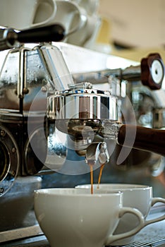 Delivering maximum flavour extraction in every cup. Coffee being brewed in cafe. Coffee cups. Making espresso with