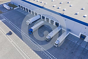 Delivering or Supply concept image. Trucks loading at facility. Logistics Center. Aerial View