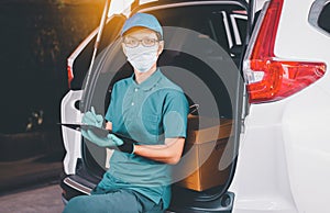Delivery asian man employee checking list on clipboard in back of van during coronavirus pandemic situation