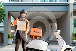 Delivery Asian man wearing orange uniform and ready to send delivering Food bag in front of customer houes with case box on