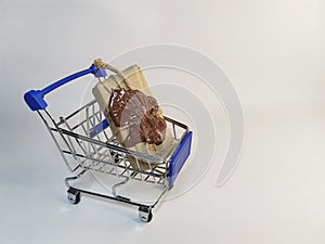 A delivery box tied with twine with a wax seal in a metal supermarket cart