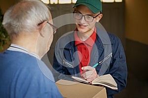 The delivery boy gives the package and mail to the elderly