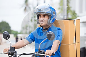 Delivery boy on motorcycle with trunk parcel box driving to fast in rush. Courier delivering order online.