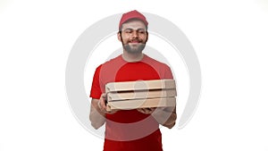 Delivery boy in a red uniform holding a stack of pizza boxes making a home delivery as seen through a spyhole. Shot with