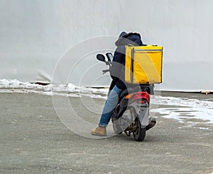 Delivery boy of takeaway on scooter with isothermal food case box. Express food delivery service from cafes and restaurants.