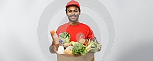 Delivery Concept - Handsome African American delivery man carrying package box of grocery food and drink from store