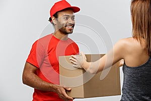 Delivery Concept - Handsome African American delivery man giving package to homeowner. Isolated on Grey studi