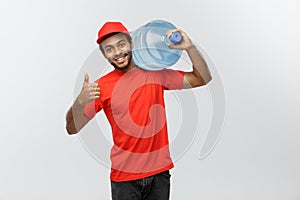 Delivery Concept - Handsome African American delivery man holding water tank. Isolated on Grey studio Background. Copy