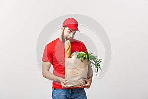 Delivery Concept - Handsome Cacasian delivery man carrying package bag of grocery food and drink from store. Isolated on