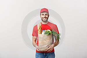 Delivery Concept - Handsome Cacasian delivery man carrying package bag of grocery food and drink from store. Isolated on