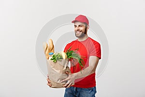 Delivery Concept - Handsome Cacasian delivery man carrying package bag of grocery food and drink from store. Isolated on