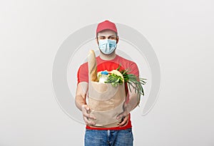 Delivery Concept - Handsome Cacasian delivery man carrying package bag of grocery food and drink from store. Isolated on