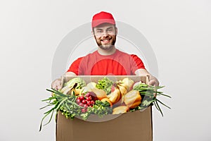 Delivery Concept - Handsome Cacasian delivery man carrying package box of grocery food and drink from store. Isolated on