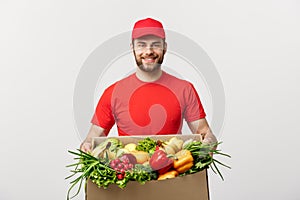 Delivery Concept - Handsome Cacasian delivery man carrying package box of grocery food and drink from store. Isolated on