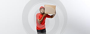 Delivery Concept - Portrait of Curious African American delivery man listen inside a box package.  on Grey