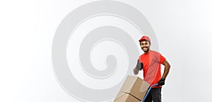 Delivery Concept - Portrait of Handsome African American delivery man or courier pushing hand truck with stack of boxes