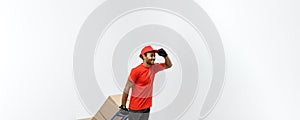 Delivery Concept - Portrait of Handsome African American delivery man or courier pushing hand truck with stack of boxes