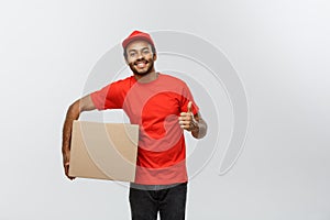 Delivery Concept - Portrait of Happy African American delivery man holding a box package and showing thumps up. Isolated