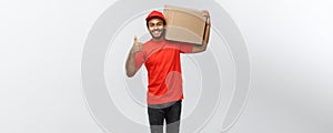 Delivery Concept - Portrait of Happy African American delivery man holding a box package and showing thumps up. Isolated