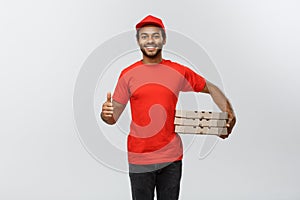 Delivery Concept - Portrait of Happy African American delivery man holding box packages and showing thumps up. Isolated