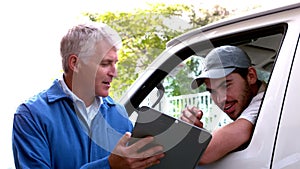 Delivery driver checking his list on clipboard with client