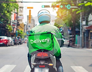 A delivery driver is driving to deliver food to customers ordering food online.