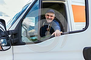 Delivery driver looking out the window of the white cargo van vehicle, delivering goods by car