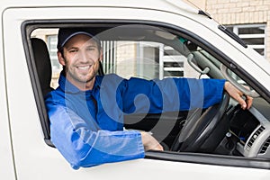 Delivery driver smiling at camera in his van