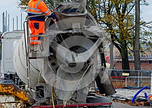 Delivery driver washing concrete vagon after delivering concrete on building site