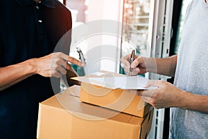 Delivery employee transport parcels pointing to documents for customers to receive products