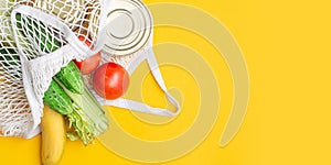 Delivery food. Food items in a string bag on a yellow background. canned food, tomatoes, cucumbers, bananas.