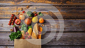 Delivery healthy food background. Healthy vegan vegetarian food in paper bag vegetables and fruits on wood, copy space, banner.