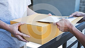 Delivery mail man giving parcel box to recipient and signature form, Young owner signing receipt of delivery package from post