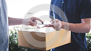 Delivery mail man giving parcel box to recipient, Young man appending signing in digital mobile phone receipt of delivery package