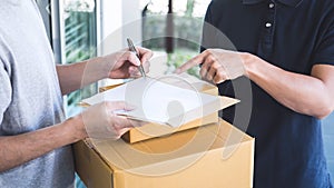 Delivery mail man giving parcel box to recipient, Young man signing receipt of delivery package from post shipment courier at home