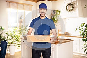 Delivery man in blue shirt and cap holding a paper box with delivering package . Concept fast delivery service or order online
