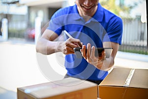 Delivery man in blue uniform  checking package on tablet before sending to the customer