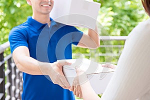 Delivery man in blue uniform delivering parcel box to a woman